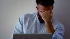 Utslitt mann ved skrivebord - mental utmattelse